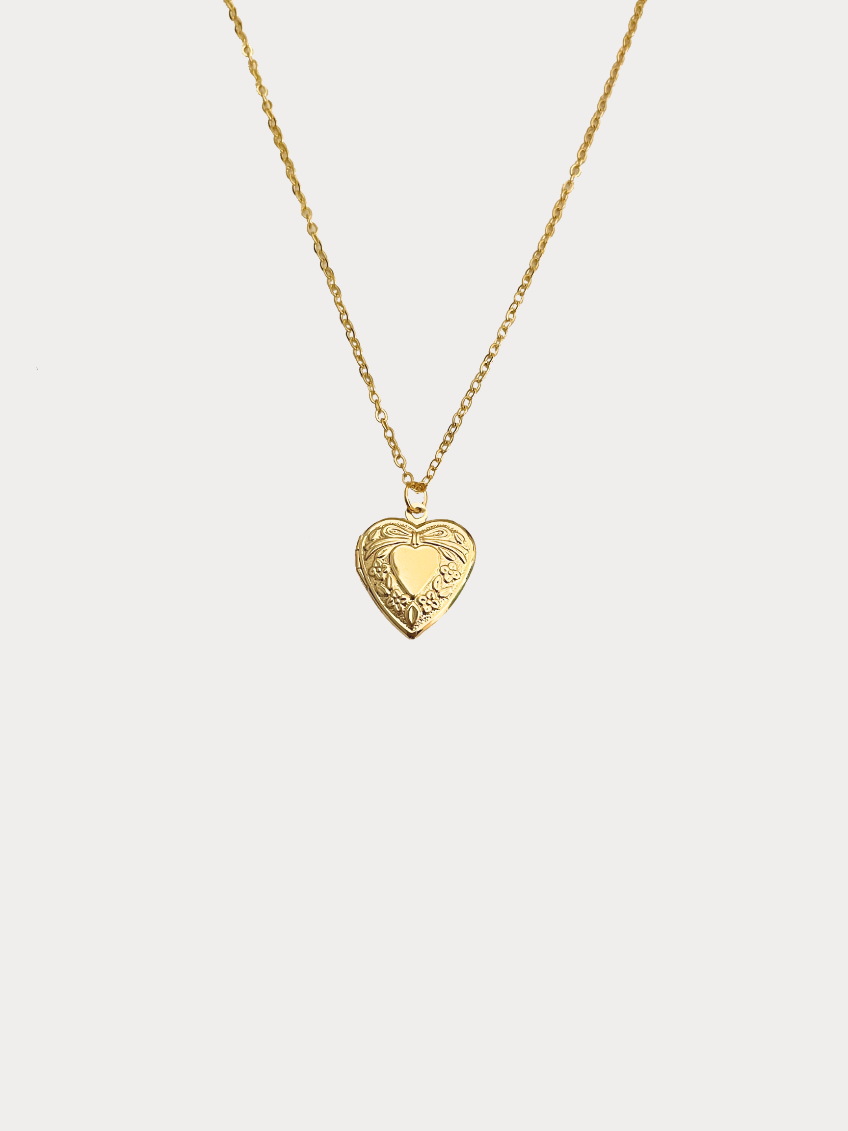 Gold classic heart locket necklace with a bow and subtle floral detailing
