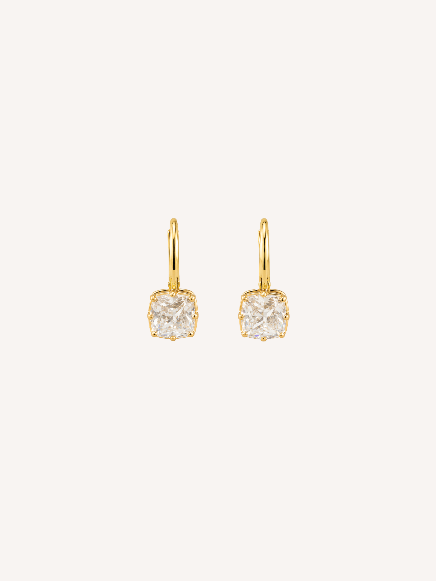 Petite gold huggie earrings with cushion-cut cubic zirconia drops in claw-prong settings.