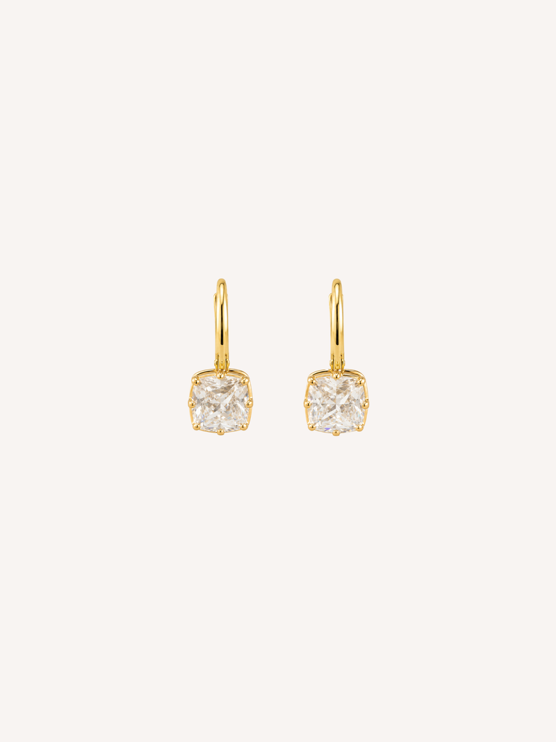 Petite gold huggie earrings with cushion-cut cubic zirconia drops in claw-prong settings.