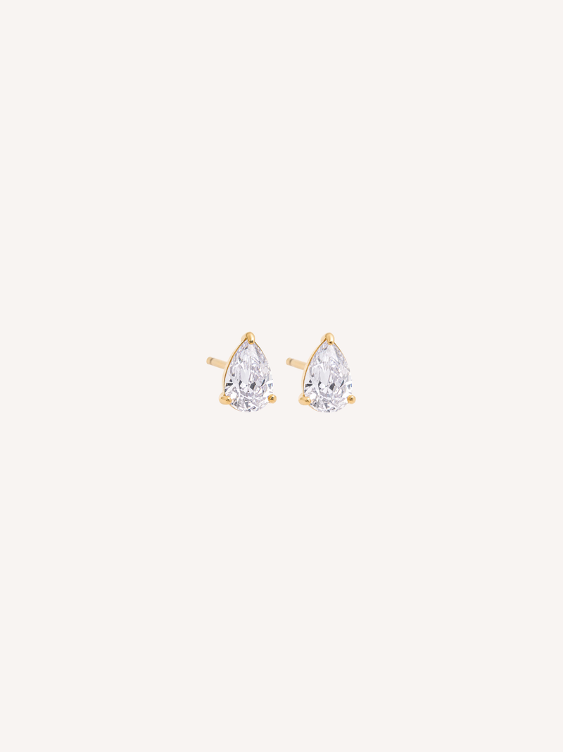 Tiny gold stud earrings with pear-cut cubic zirconia stones held by claw prongs.