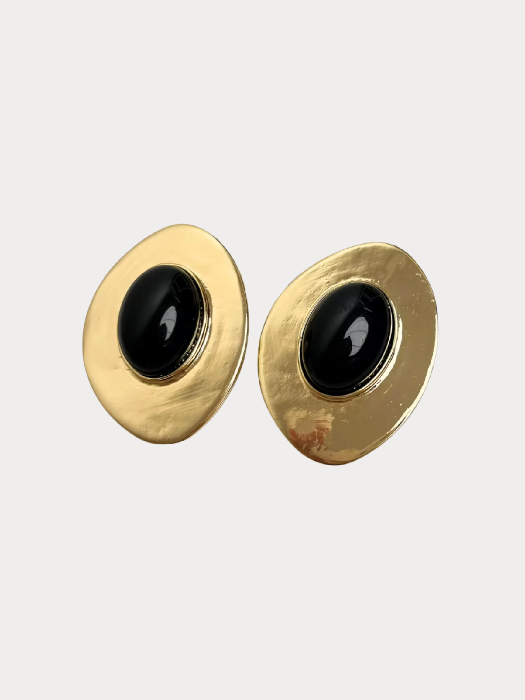 gold sculptural oval earrings with black center stone and organic textured finish