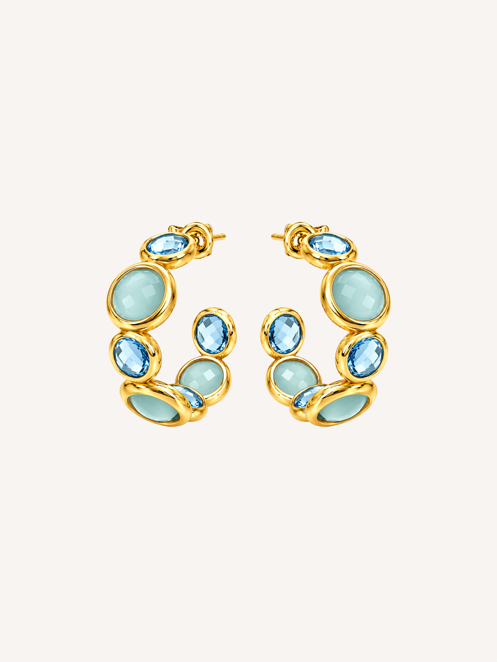 Blue statement gold hoop earrings featuring blue glass and cubic zirconia stones.