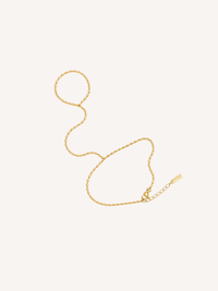 Gold beaded hand chain featuring an elongated bead chain design connecting the finger and wrist.