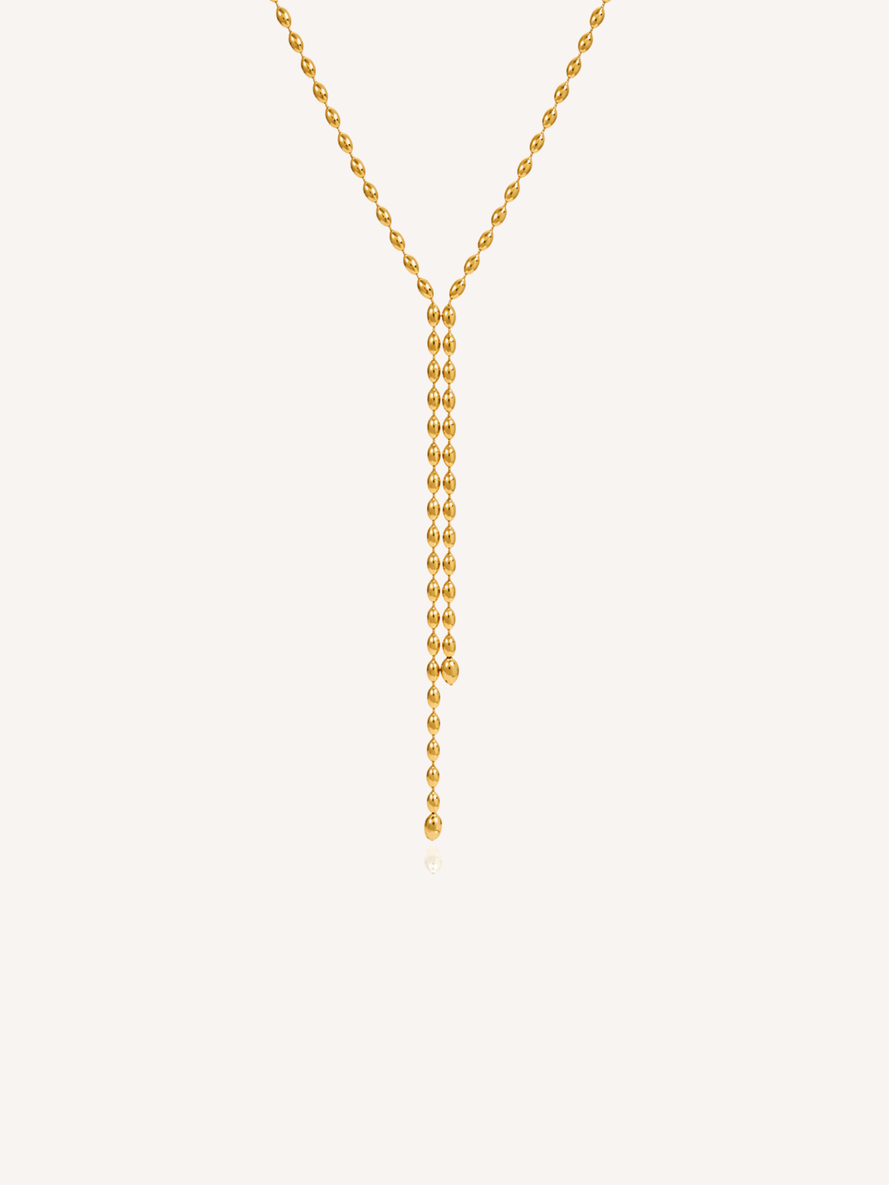 Gold lariat necklace featuring a delicate beaded chain and elongated Y-shaped drop design.