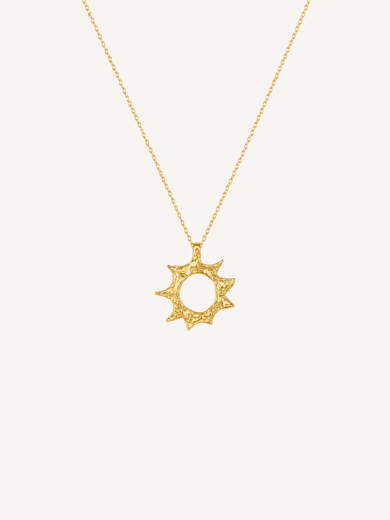 Gold sun pendant necklace with an organically textured finish and irregular sunburst silhouette.